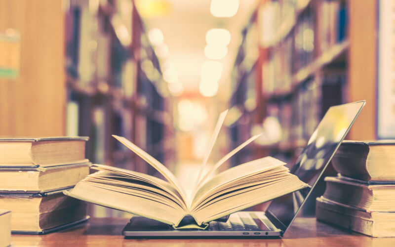 An image depicting a book open on a laptop in the research archive in a library.