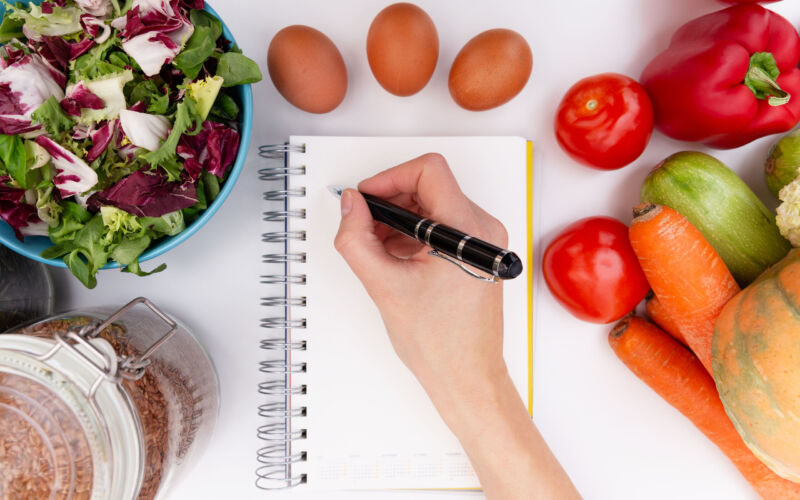 An image depicting a dietitian writing in a notebook.